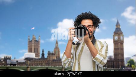 sorridente uomo o fotografo con fotocamera a londra Foto Stock