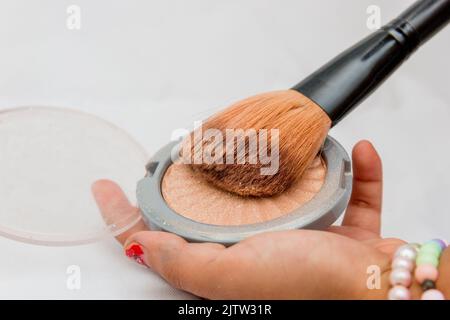 Trucco, polvere compatta con pennello su una mano bianca a Rio de Janeiro Brasile. Foto Stock