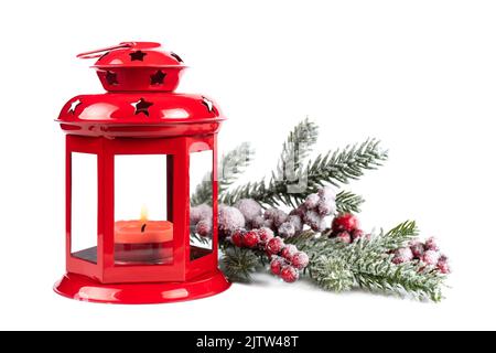 Lanterna rossa bruciante con ramo ornato di abete innevato isolato su sfondo bianco Foto Stock