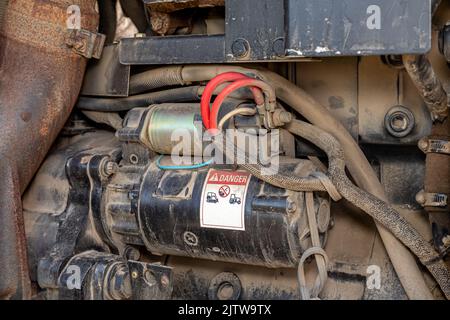 Motorino di avviamento del motore sul trattore agricolo. Concetto di riparazione, manutenzione e assistenza delle attrezzature agricole e agricole Foto Stock