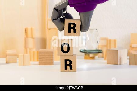 ROR la parola su cubi di legno, cubi in piedi su una superficie riflettente, sullo sfondo è un business diagramma. Concetto di business e finanza. ror - breve Foto Stock