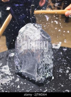 Processo di rottura del ghiaccio con martello e raccogli ghiaccio, gruppo di persone che distruggono il cubo di ghiaccio frantumato, concetto di successo del lavoro di squadra, concetto di partenza pari Foto Stock