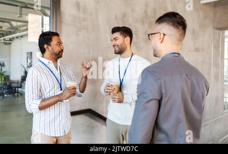 uomini d'affari che bevono caffè da asporto in ufficio Foto Stock