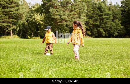 bambini piccoli con la palla che gioca a calcio al parco Foto Stock