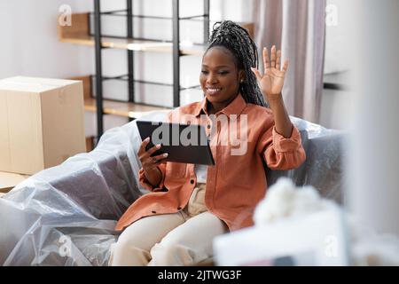 donna sorridente con un tablet pc che videochiama Foto Stock