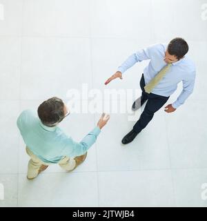 È un piacere incontrarvi. Scatto ad angolo alto di due uomini d'affari che scuotono le mani in ufficio. Foto Stock
