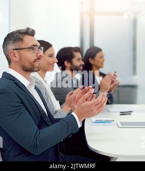 Un gruppo di uomini d'affari che stringono le mani in un ufficio moderno. Foto Stock