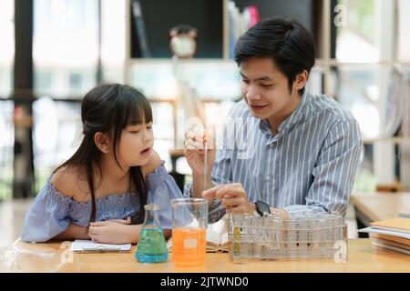 Bambino e padre che fanno esperimenti scientifici. Concetto di scienza dell'istruzione Foto Stock