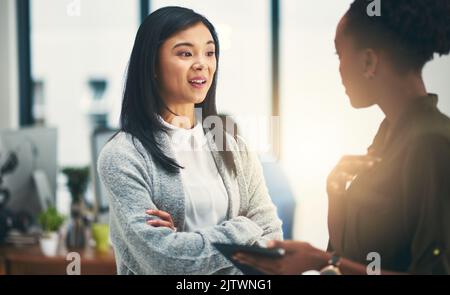 Theyre entrambi sulla stessa pagina. Due giovani creativi che hanno una discussione in un ufficio. Foto Stock