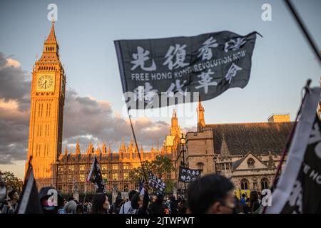 Londra, Regno Unito. 31st ago, 2022. Durante la manifestazione, un manifestante si è fatto un vessillo davanti al Palazzo di Westminster. I manifestanti si sono riuniti a Londra il terzo anniversario della presenza della polizia di Hong Kong in una stazione della metropolitana e hanno picchiato i manifestanti e i pendolari, un evento che secondo gli attivisti pro-democrazia esemplifica l'impunità e gli abusi della polizia di Hong Kong. Credit: SOPA Images Limited/Alamy Live News Foto Stock