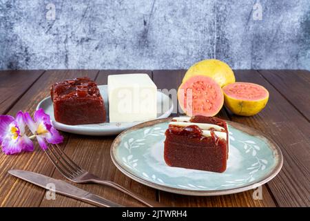 Fette di guava dolce e formaggio cagliato accanto a un fiore, forchetta e coltello di rame. Foto Stock