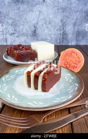 Fette di guava dolce e formaggio cagliato accanto a un coltello di rame e vista laterale verticale fork. Foto Stock