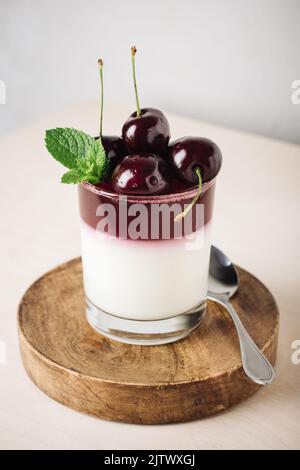 Dessert di gelatina. Yogurt e gelatina di ciliegia in un bicchiere. Foto Stock