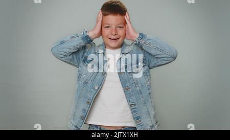 OH mio Dio, Wow. Eccitato stupito vincitore bambini ragazzo alzando le mani in sorpresa guardando la telecamera con grandi occhi, scioccato da improvvisa vittoria. Bambino giovane adolescente sincero isolato su sfondo grigio studio Foto Stock