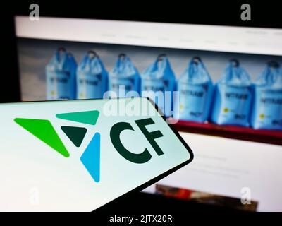 Smartphone con logo della società americana di fertilizzanti CF Industries Holdings Inc. Sullo schermo di fronte al sito Web. Messa a fuoco sul lato destro del display del telefono. Foto Stock