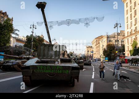 Kiev, Ucraina. 24th ago, 2022. Le persone camminano il loro cane per le strade accanto alla distruzione di artiglieria russa a Kiev. In occasione della Giornata dell'Indipendenza dell'Ucraina, E quasi 6 mesi dopo l'invasione su larga scala dell'Ucraina il 24 febbraio, la capitale del paese Kyiv tiene una mostra sulla strada principale di Khreschaytk Street che mostra le attrezzature militari, i carri armati e le armi distrutte dalle forze armate della Federazione Russa (Credit Image: © Alex Chan Tsz Yuk/SOPA Images via ZUMA Press Wire) Foto Stock