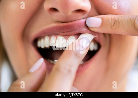 Donna masticare umido umido fumo tabacco Snus prodotto Foto Stock