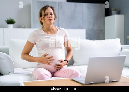Giovane donna incinta che soffrono di nausea a casa Foto Stock