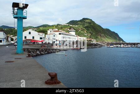 Il lungomare della città e la marina, arrugginito ormeggio scarpe sul cemento ormeggio in prima linea, Povoacao, Sao Miguel Island, Azzorre, Portogallo Foto Stock