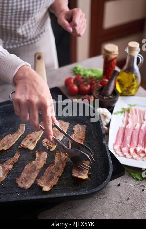 Fettine di bacon che si friggono sulla griglia padella padella Skillet in cucina domestica Foto Stock