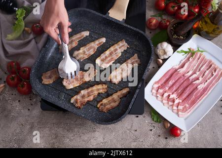 Fettine di bacon che si friggono sulla griglia padella padella Skillet in cucina domestica Foto Stock