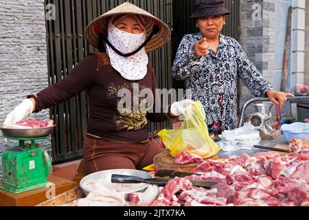 Vietnamita signora macellaio che vende carne nel mercato di strada, Hai Phong, Vietnam Foto Stock