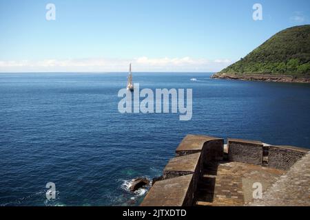 Vista sull'oceano dal forte di Sao Sebastiao, parte del bastione d'angolo, nave alta ancorata offshore, Angra do Heroismo, Terceira, Portogallo Foto Stock