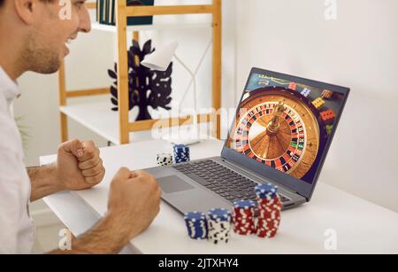 Lucky gambling man vince un sacco di soldi sul sito web del casinò online sul computer portatile Foto Stock