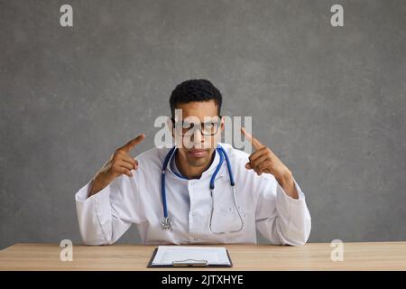 L'uomo americano arrabbiato si mostra allettante che sta sperimentando mal di testa e stanchezza. Foto Stock