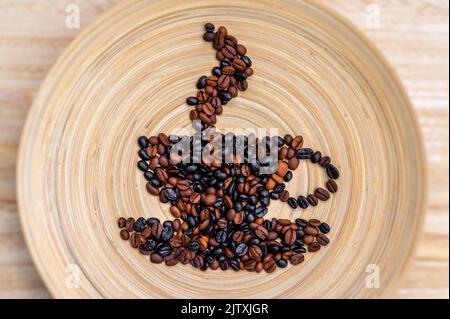 Simbolo di una tazza di caffè fumante con i chicchi di caffè posizionati su uno sfondo di legno Foto Stock