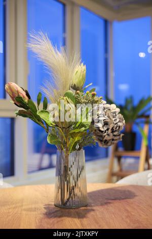 Bouquet di fiori di ortensia e protea in un vaso sul tavolo Foto Stock