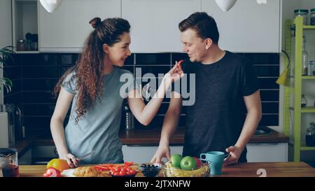 positivo giovane coppia caucasica divertirsi a cucinare in cucina a casa Foto Stock