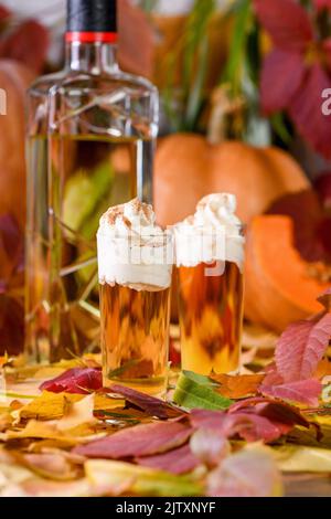 Due vodka con torta di zucca crema alla cannella spara in bicchieri da shot. Queste bevande sono facili da preparare e perfette per l'autunno. Prova queste bevande boozy al tuo Foto Stock