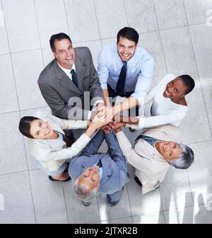 I nostri team hanno ottenuto questo risultato. Foto di un gruppo di colleghi con le mani in una bacchetta. Foto Stock