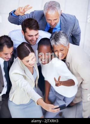 Facciamo una divertente foto di squadra. Foto di un gruppo di uomini d'affari diversi che scattano una foto di squadra. Foto Stock