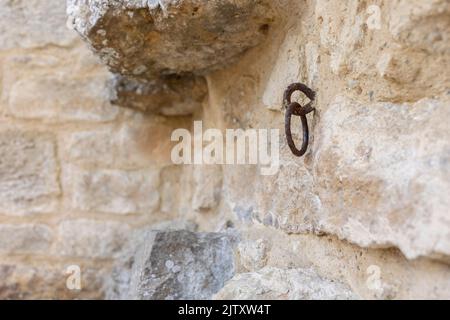 Vecchio anello di ferro arrugginito in un antico muro di arenaria castello, fuoco selettivo, sfocatura sfondo, copia spazio Foto Stock