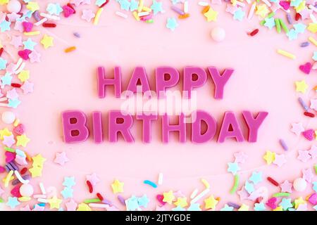 Torta di compleanno rosata con cioccolato rosa buon compleanno messaggio e spolverate Foto Stock