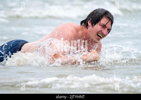 Uomo che gioca sulla spiaggia Foto Stock