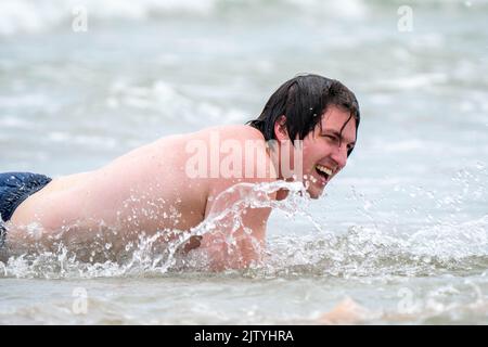 Uomo che gioca sulla spiaggia Foto Stock