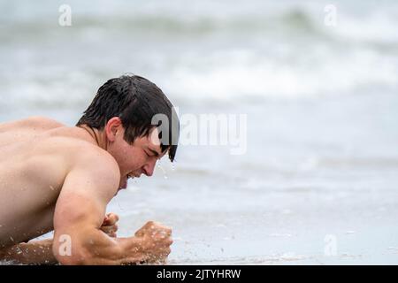 Uomo che gioca sulla spiaggia Foto Stock