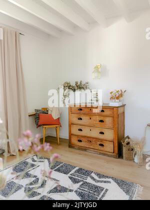 Interni accoglienti in tonalità naturali con mobili in legno antico, soffitti con travi a vista e fiori secchi come eucalipto. Design rustico moderno. Foto Stock