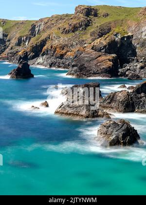 Rallentamento del tempo di scatto per una velocità dell'otturatore prolungata nella baia di Kynance. Mare estivo tropicale con morbide onde nebbie. Paradiso. Foto Stock