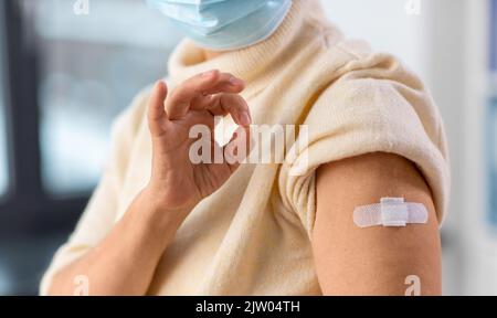 donna anziana vaccinata con cerotto medico sul braccio Foto Stock