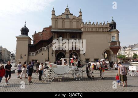 Carrozza trainata da cavalli che offre gite ai turisti in Piazza del mercato, Cracovia, Polonia Foto Stock