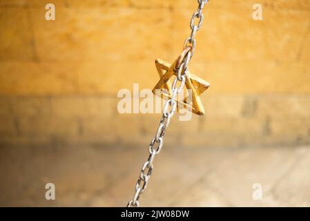 Stella di Davide in una catena. Parete. Copia spazio per il testo. Simboli di religione. Segnali. Foto Stock