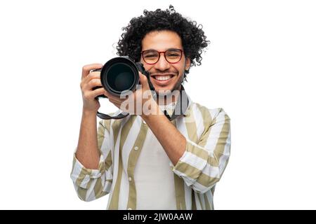 uomo sorridente o fotografo con fotocamera digitale Foto Stock