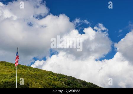 Un Flay degli Stati Uniti è sospeso da un palo sotto i cieli nuvolosi di fronte ad una collina nella Carolina del Nord Foto Stock