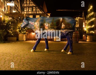 Gengenbach, Germania - 13 dicembre 2020: Vacca dipinta con i punti di riferimento in diverse parti del mondo di notte a Gengenbach, Germania. Foto Stock