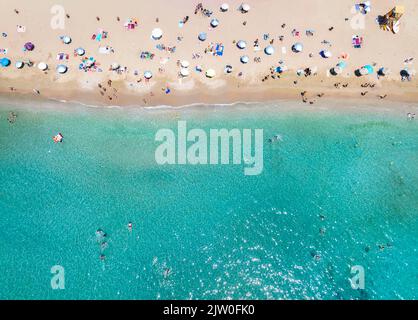 Vista aerea dall'alto verso il basso di una spiaggia affollata con mare turchese Foto Stock