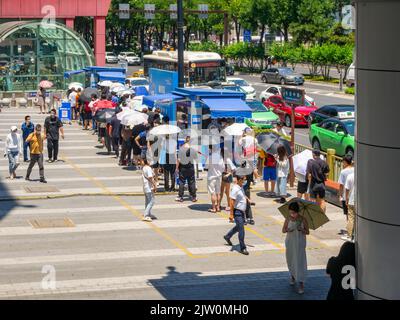 Gente cinese che si allinea in su per un test di Covid-19 nel distretto del centro. Foto Stock